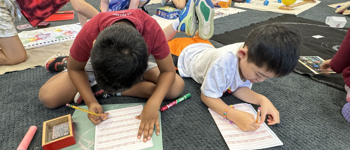 Children working on worksheets on the floor