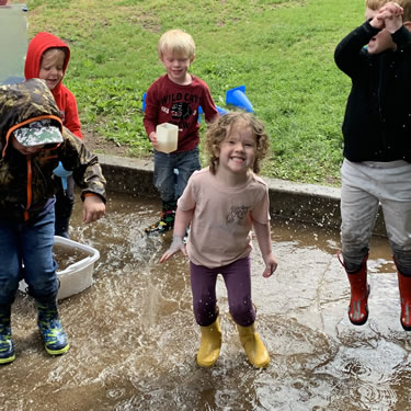 Toddlers playing in large puddle